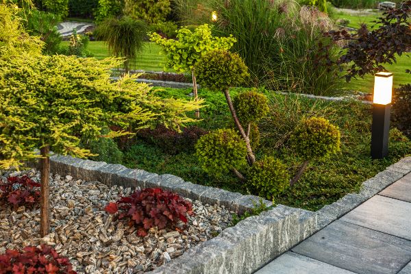 Transitional design next to new walkway with gravel and quartz blocks.