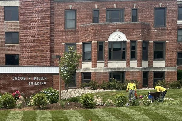 Custom Exterior Landscape staffers maintaining and weeding a commercial garden.