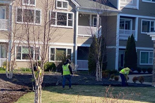 Custom Exterior Landscape staffers maintaining and weeding a garden at a condominium